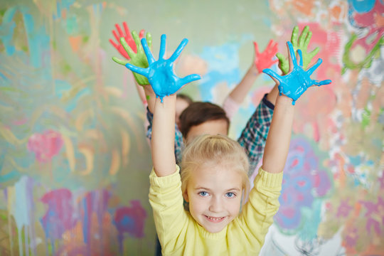 Cheerful kids raising their painted palms