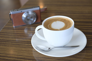 Cafe latte and digital camera on table