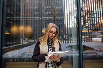 Fototapeta premium Young business woman looking through the papers outside