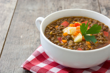 Lentil soup in a bowl on wooden background
