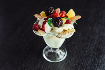 Ice cream with fruit in ramekin.