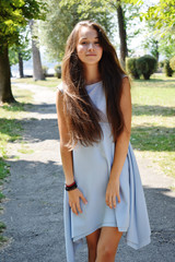Naklejka premium Portrait of beautiful teenage girl in blue blouse, against green