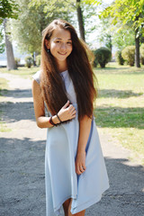 Portrait of beautiful teenage girl in blue blouse, against green