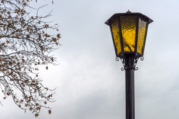 Fototapeta na wymiar Traditional street lamp under the cloudy sky.