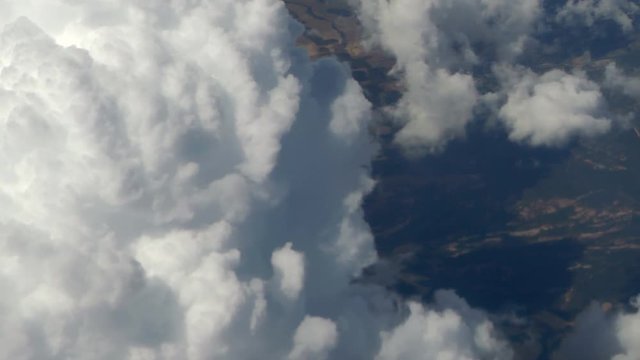 Close up large Clouds over the ground, seen from above and that slowly pass from right to left. Aerial shot. Top view.
