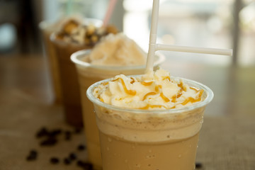 Iced caramel coffee frappe with whipped cream in plastic glass