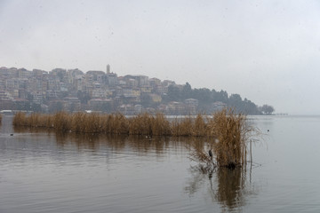 Foggy winter scenery at the lake of Kastoria Greece, during a he - 136320320