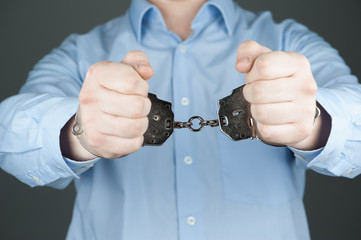 Man in handcuffs and blue shirt