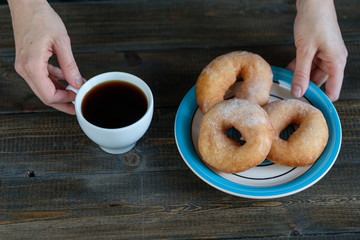 woman drinks coffee with donuts
