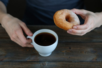 woman drinks coffee with donuts