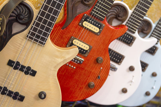 Many colorful electric guitars aligned in a store showroom, body