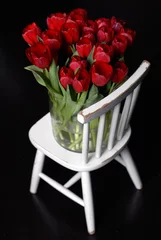 Gordijnen een bos rode tulpen op een witte stoel © Carmela