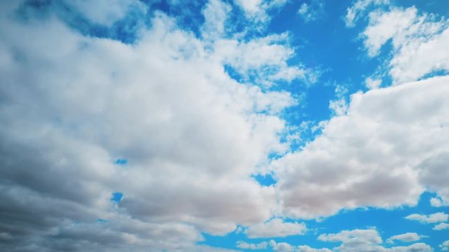 Timelapse shot of fluffy clouds rolling in sky. Aerial footage of cloudscape against blue sky. Scenic view of nature on sunny day. 4K resolution.
