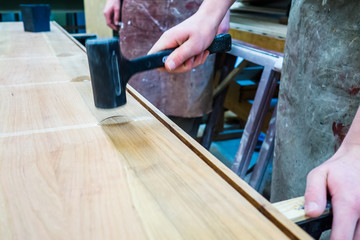 Schreiner hämmert Holzdübel in Brett