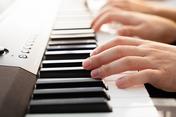Closeup of hands playing piano. Music and hobby concept