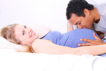 Husband kissing pregnant wife's belly