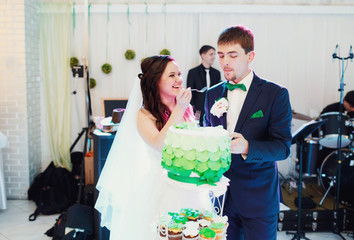 Bride feeds the groom first pieces of the wedding cake