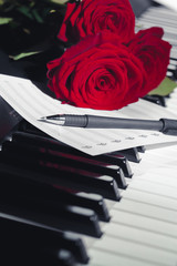 red roses on piano keys