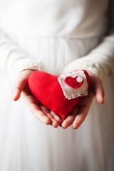 Hands holding red textile heart
