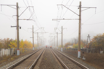 Fototapeta na wymiar railway in fog in autumn, cloudiness