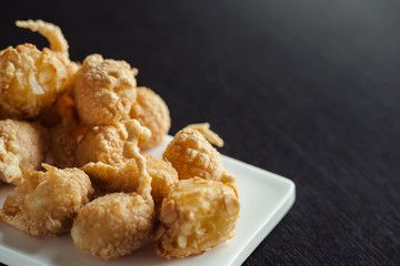 Cheese balls for beer on a white plate on a wooden table