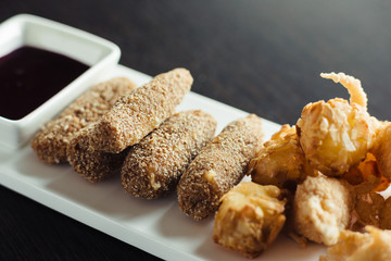 Cheese balls for beer on a white plate on a wooden table