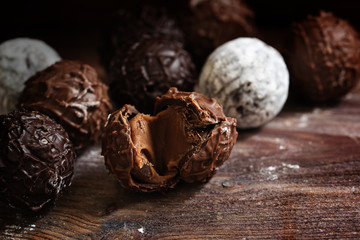 Chocolate, truffle pralines with nougat cream on dark rustic wood
