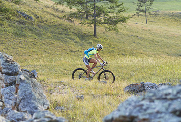 young girl on mountain bike among the rocks, cycling