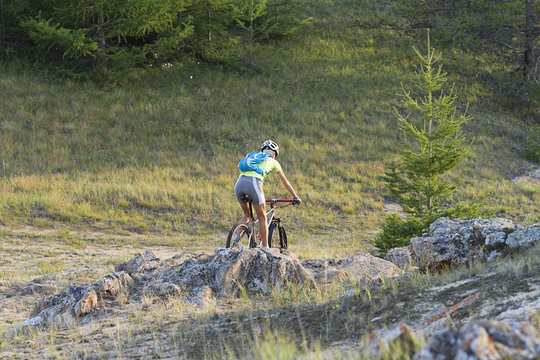young girl on mountain bike among the rocks, cycling