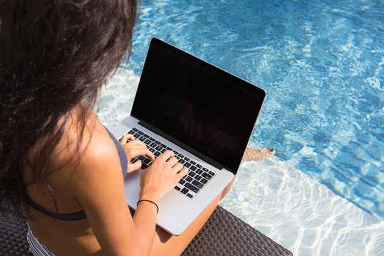 Beautiful Girl Working On Notebook By The Swimming Pool