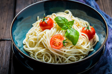 Closeup of spaghetti with tomatoes, basil and parmesan