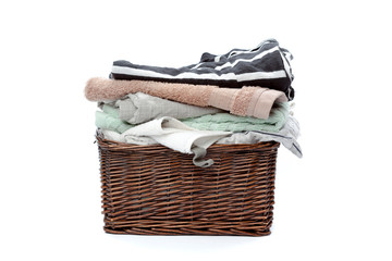Obraz premium Clothes in a laundry wooden basket isolated on white background