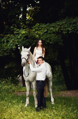 Fototapeta premium groom holds the horse bride could ride