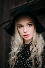 Beautiful attractive and stylish girl wearing black hat standing posing in city. Nude makeup, best daily hairstyle and great fashion glamour country style.