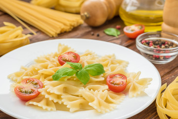 Fresh cooked farfalle with cut tomatoes and basil