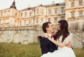 Fototapeta premium smiling groom holding hands in a happy bride