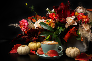 Cappuccino coffee and flowers composition on black background