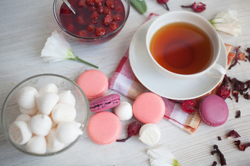Serving table: tea with marshmallow, berry jam and macaroons.