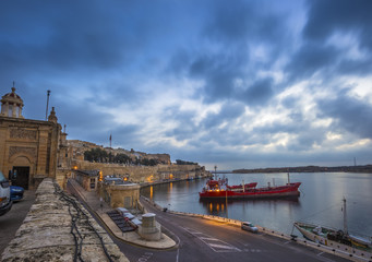 Fototapeta premium Valletta, Malta - Beautiful dawn and morning lights at the ancient walls of Valletta waterfront with ships and nice blue clouds