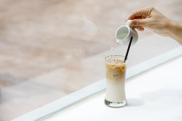 iced coffee latte close up on white wood background and syrup