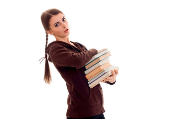 beautiful young brunette student girl with a lot of books in hands isolated on white background