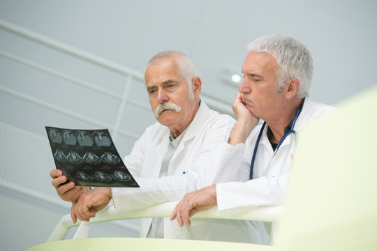 Senior medics looking puzzled over xray