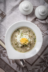 Sorrel soup with egg in white bowl.