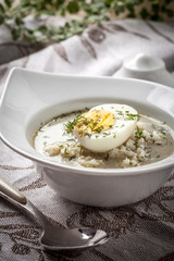 Sorrel soup with egg in white bowl.
