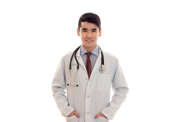 cheerful male doctor with stethoscope in uniform posing isolated on white background