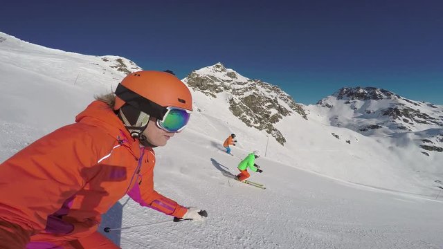 4k footage, four good skiers skiing down ski slope on sunny winter day with blue sky
