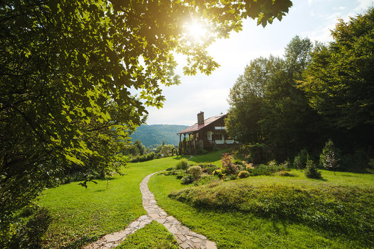 Fototapeta Beautiful house in high mountains during summer.