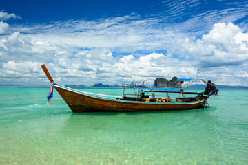 Naklejka na ściany i meble Traditional travel boat in sea with green water