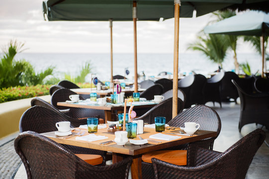 Outdoor Restaurant on the Beach in Mexico. Inviting Table with Mexican Decorations. Ocean in Background.