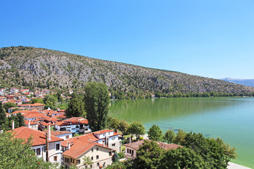 Fototapeta na wymiar Stone traditional houses and lake Orestiada in Kastoria city (Epirus, Greece)